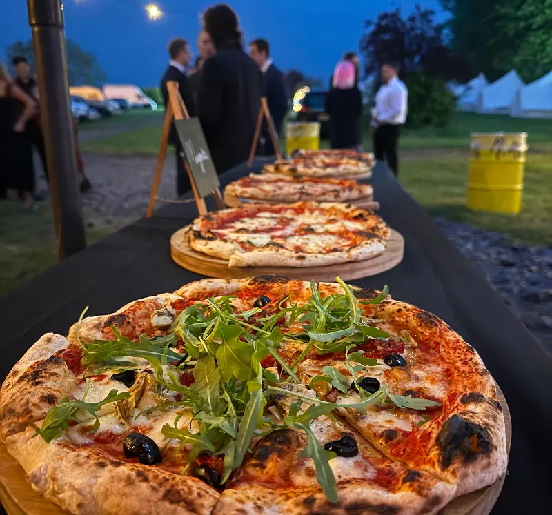 Fresh stone baked pizzas served at an outdoor wedding reception by The Piccolo Box