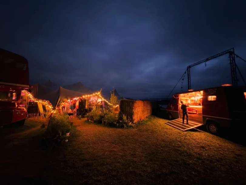 The Piccolo Box pizza van lit up at an evening event