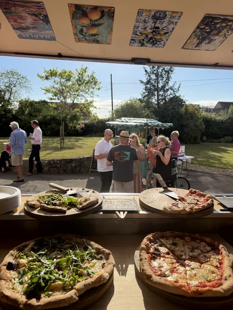 Guests enjoying pizza from The Piccolo Box van at a garden party